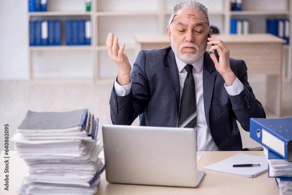 Old male employee and too much work at workplace Old male employee and too much work at workplace