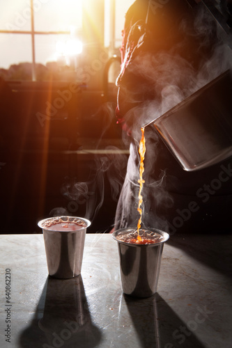 Woman pouring steaming hot health drink for cold  photo