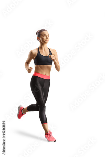 Young woman in matching leggings and crop top jogging