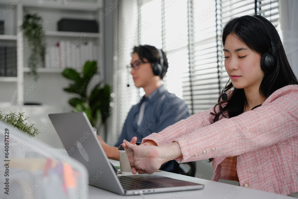 woman is sitting with her laptop and her wrist aches while working at ...