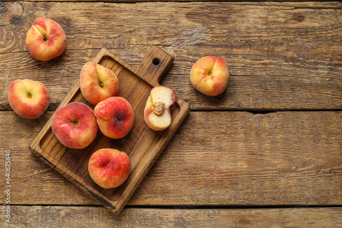 Board with sweet fig peaches on wooden background