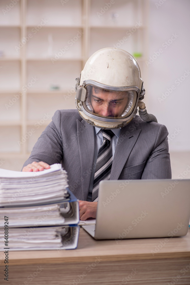 Young male employee wearing spacesuit in the office Young male employee wearing spacesuit in the office
