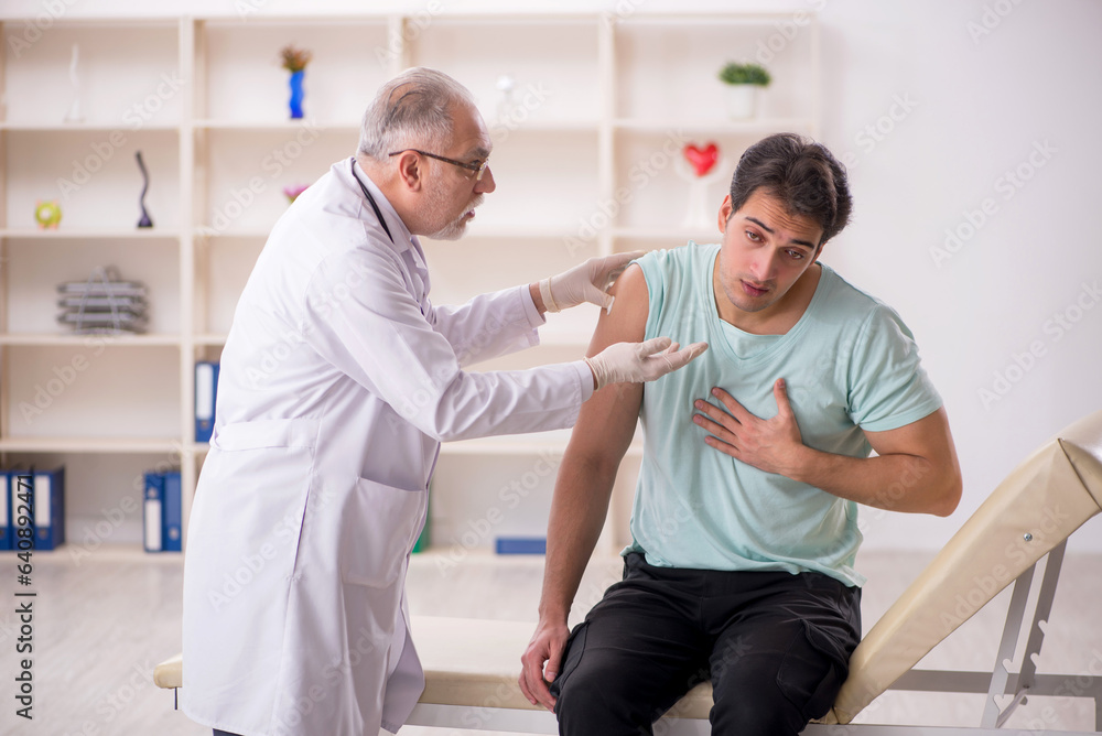 Obraz premium Young male patient visiting old male doctor in vaccination conce