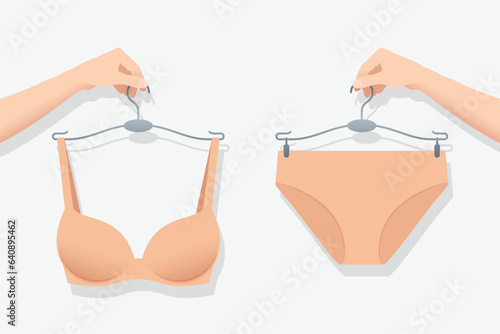 Panty and bra in flesh color on hangers in hands of woman
