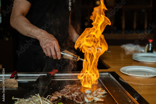 Obraz na plátně Chef cooking in Japanese teppanyaki restaurant