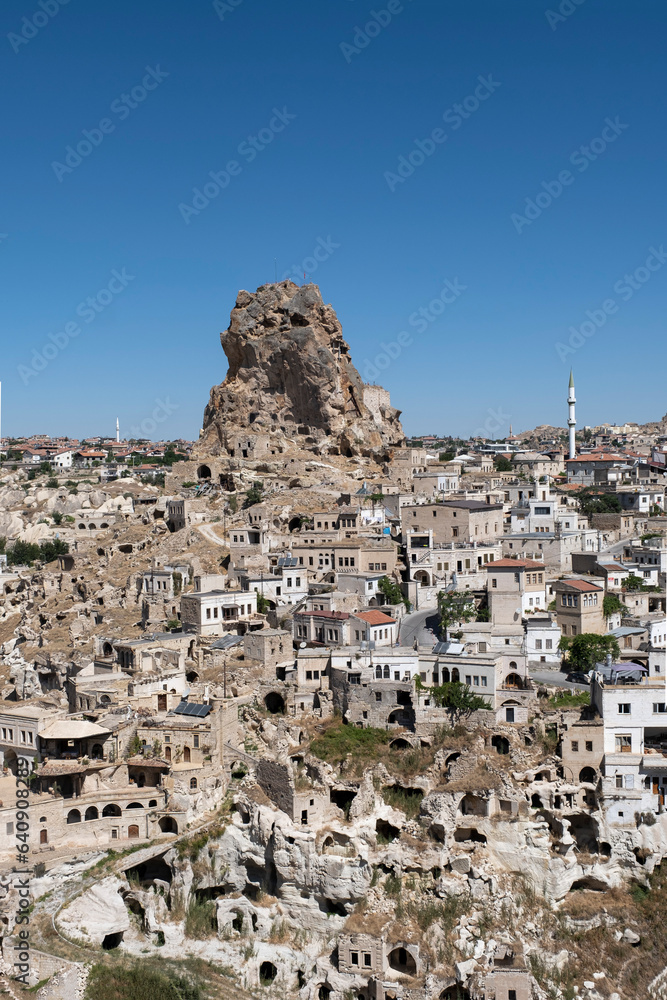 Ortahisar, typical village carved in rock and stone with the castle of Ortahisar on a large volcanic rock that crowns the village, Cappadocia, Anatolia, Turkey, vertical Ortahisar, typical village carved in rock and stone with the castle of Ortahisar on a large volcanic rock that crowns the village, Cappadocia, Anatolia, Turkey, vertical