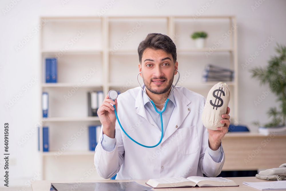 Young male doctor in remuneration concept Young male doctor in remuneration concept