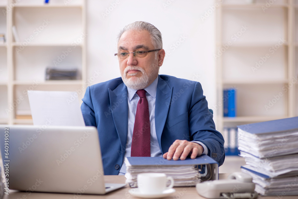Old male employee and too much work at workplace Old male employee and too much work at workplace