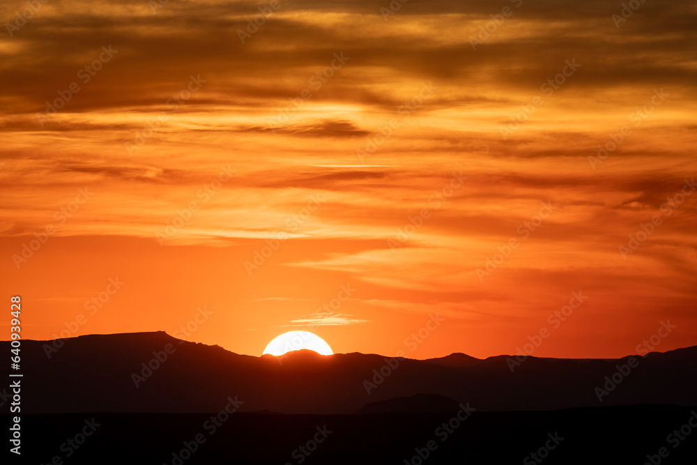 Sun Drops below Silhouette of Mountains