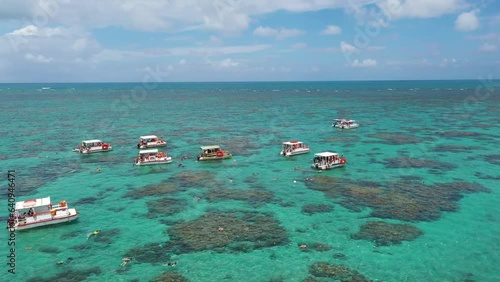 Fantastic view of boats in the open ocean with tourists swiming above coral reefs of Maracajau city near Natal in Rio Grande do Norte, Brazil  photo