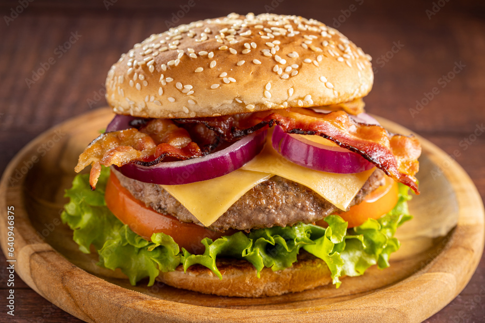 Delicious hamburger with meat, cheese, bacon and salad.