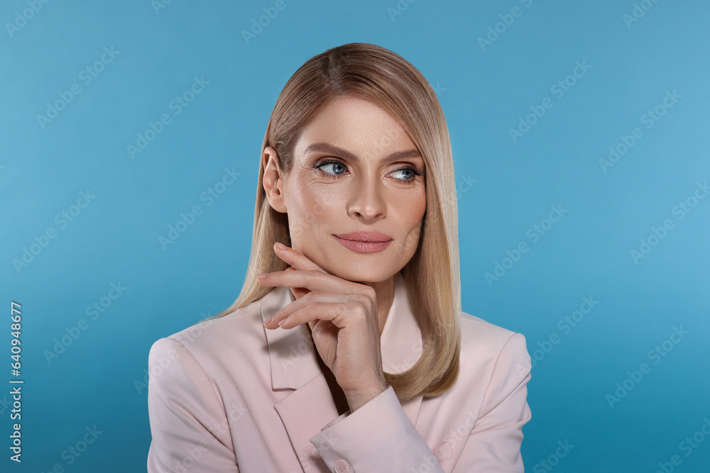Portrait of stylish attractive woman with blonde hair on light blue background Portrait of stylish attractive woman with blonde hair on light blue background