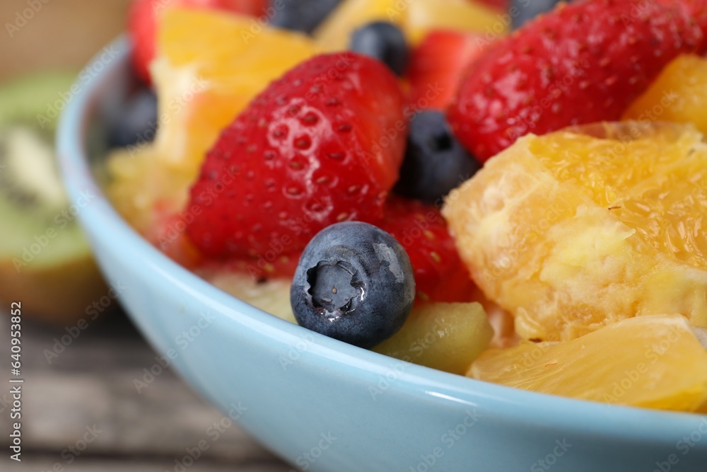 Delicious fresh fruit salad in bowl on table, closeup Delicious fresh fruit salad in bowl on table, closeup