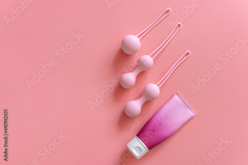 Pink balls and lubricant for special exercises for woman. Balls for intimate muscles of women. Kegel balls for strenthening the pelvic floor muscles, vaginal muscles. Mock up. Close up photo