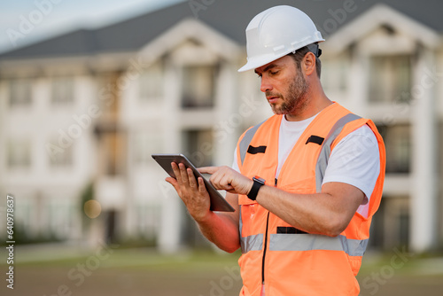 Engineer with tablet, building inspection. Portrait of builder man. Construction worker with hardhat helmet on construction site. Construction engineer worker in builder uniform. Worker construction.