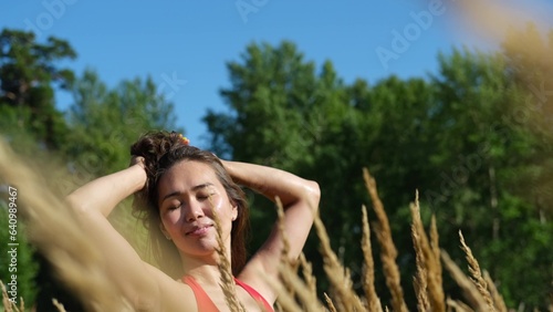 Portrait of a beautiful asian woman on the background of dry long grass while relaxing in summer. slow motion portrait. photo