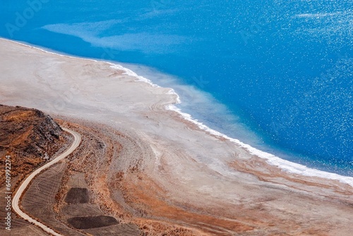 Capture the breathtaking beauty of the azure-colored Yamdrok Tso lake in tranquil Tibet, with its serene waters reflecting the pristine Tibetan landscape.