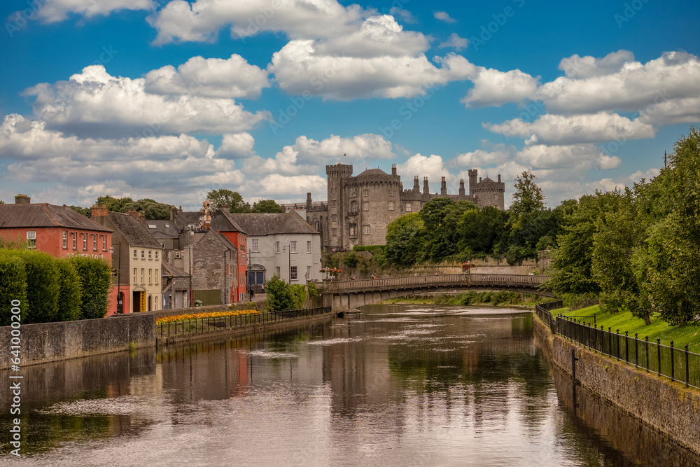 Classic view of Kilkenny castle from the river Nore with cloudy blue sky