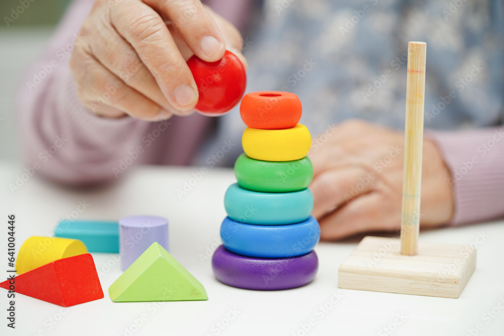 Asian elderly woman playing puzzles game to practice brain training for dementia prevention, Alzheimer disease. Asian elderly woman playing puzzles game to practice brain training for dementia prevention, Alzheimer disease.