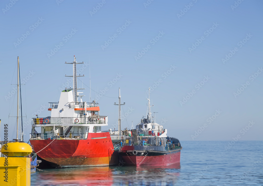 Group of moored ships against clear blue sky