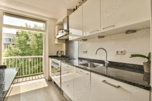 a kitchen with white cabinets and black granite counter tops in front of the window looking out onto the street outside
