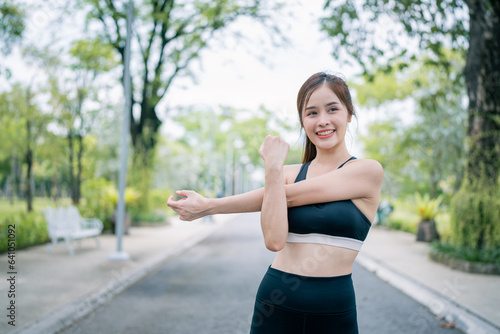 Portrait of young woman in fitness wear exercising in park. Healthy Concept, copy space.