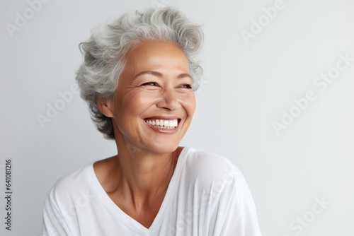 Beautiful gorgeous 50s mid age beautiful elderly senior model woman with grey hair laughing and smiling. Mature old lady close up portrait. Healthy face skin care beauty, skincare cosmetics, dental.