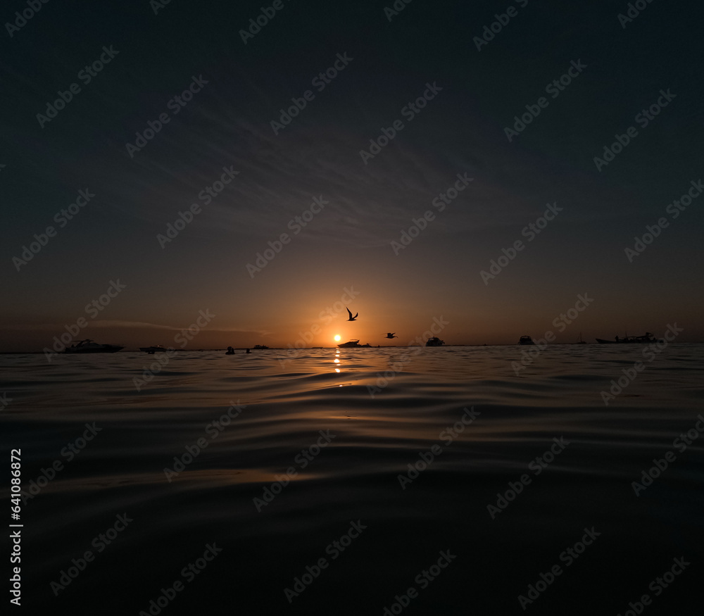 photo of beautiful yellow sunset seen from the sea enjoying a different and unique vacation in Isla Mujeres, Mexico taken with a gopro in high definition