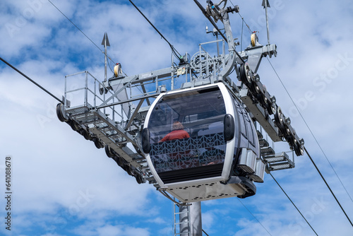 Close-up of a cable car cabin against the sky. Cable car trip to viewpoints in the mountains. During the trip by cable car Tourists enjoy beautiful views and experience exciting.