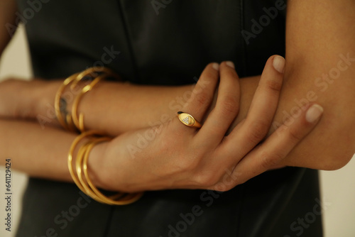Close-up of female hands showing her golden bracelet. Horizontal mock-up.
