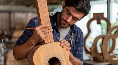 Guitar makers man making acoustic guitars in laboratory. Asian guitar maker builds high quality guitars for musicians handmade guitar shop.
