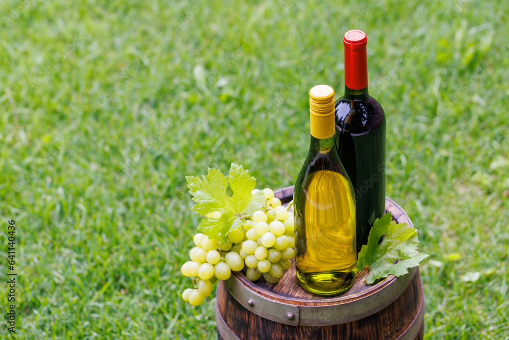 Fototapeta premium Wine bottles and grape on barrel