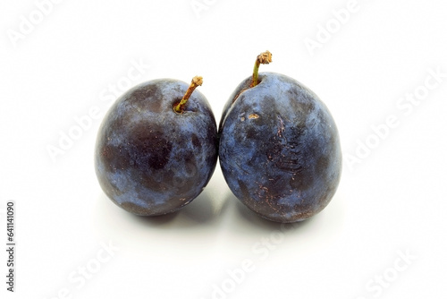 Two violet plums on a white background