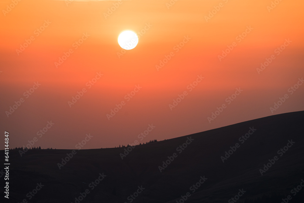 Fototapeta premium The sun sets on the mountain. Beautiful sunset in a mountainous area.
