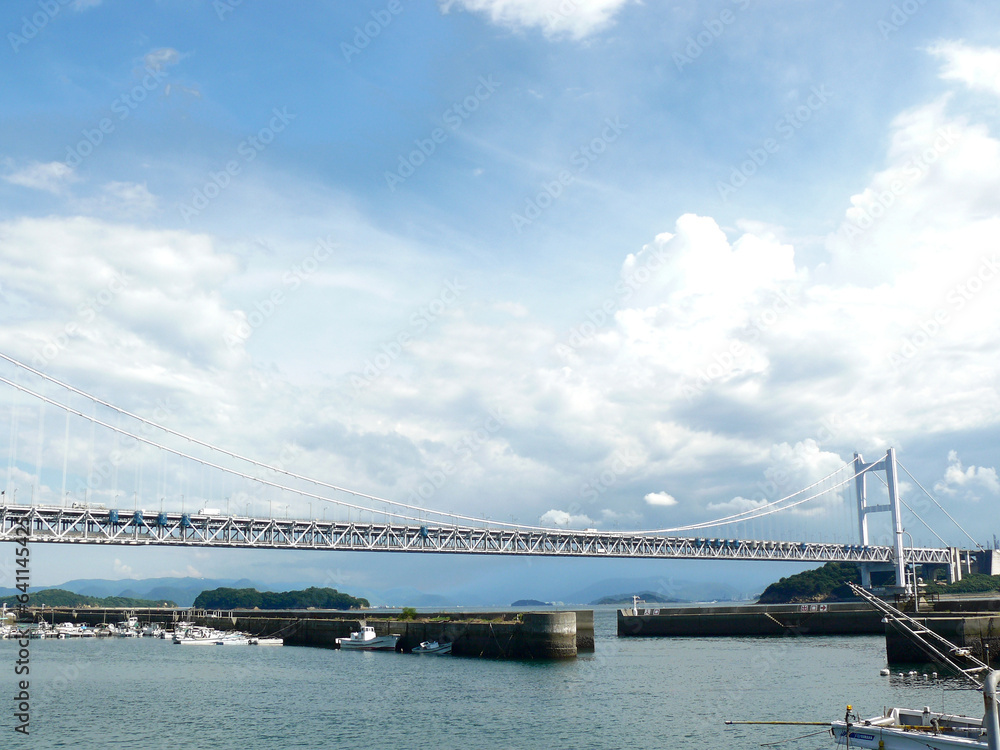Fototapeta premium 港入り口を構成する防波堤。 背景は瀬戸大橋。 瀬戸内海の風景。