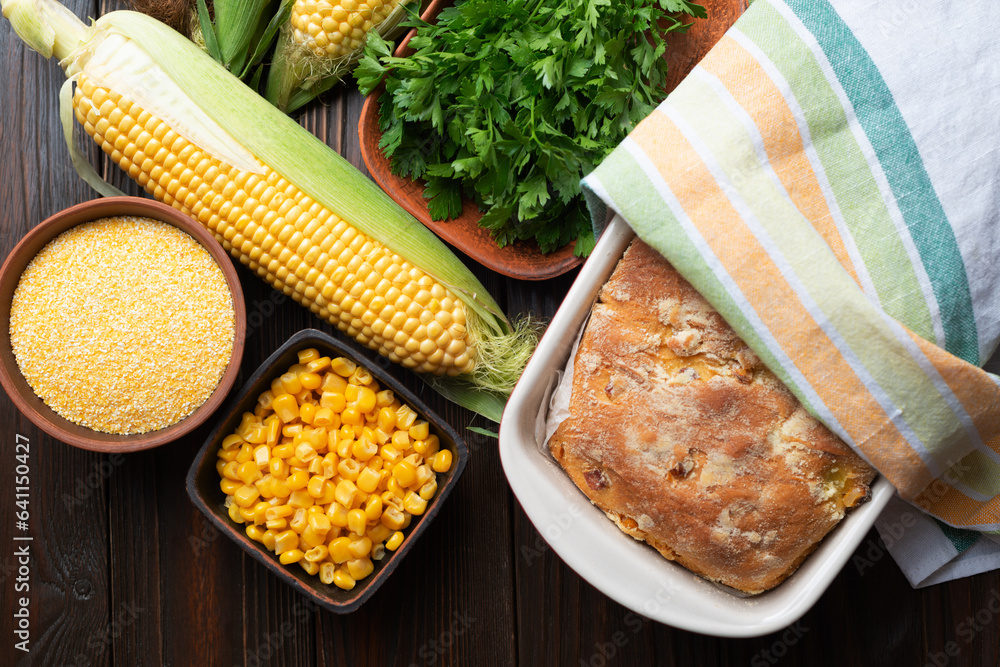 Cornbread in ceramic baking dish on wooden kitchen table flat lay view