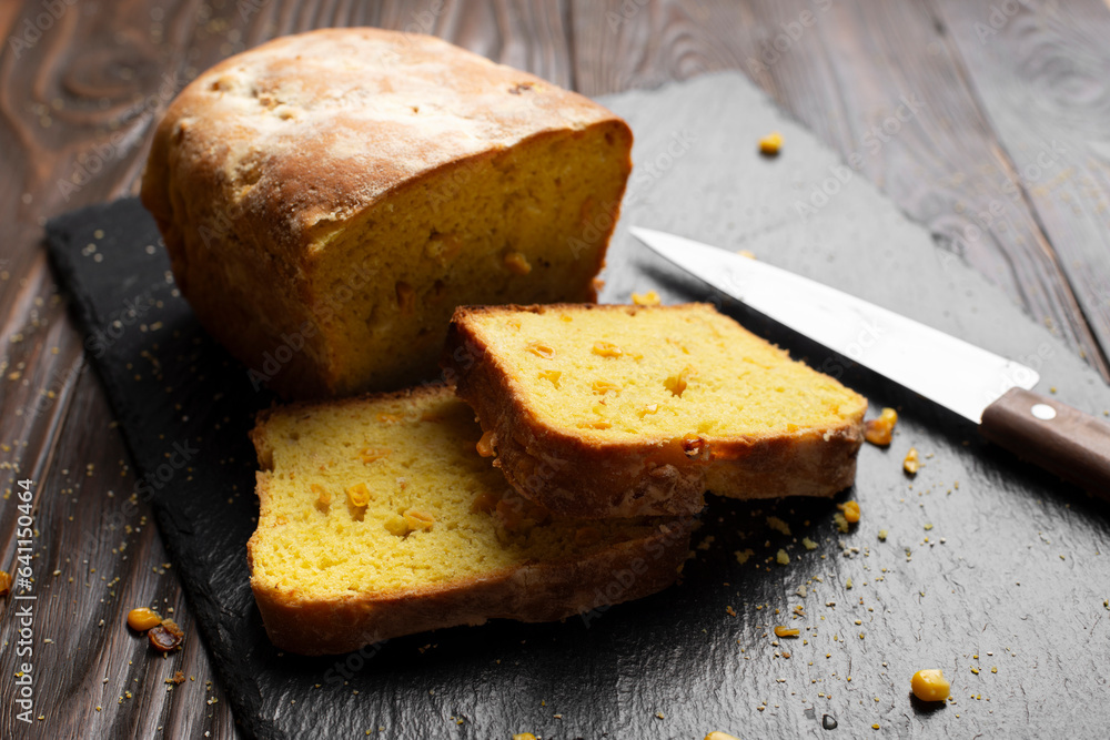 Homemade cornbread loaf and slices on kitchen table