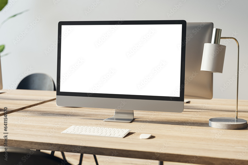 Close up of empty white computer screen on wooden office desktop with lamp and supplies on concrete wall background. Designer workplace concept. Mock up, 3D Rendering. Close up of empty white computer screen on wooden office desktop with lamp and supplies on concrete wall background. Designer workplace concept. Mock up, 3D Rendering.