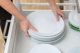 Duże białe talerze wyjmowane z szafki kuchennej