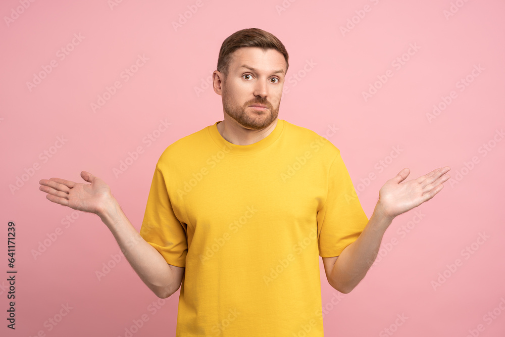 Confused man spreading hands shrugging shoulders what happened solves the dilemma, isolated background. Studio portrait puzzled male with funny impressed emotion with uncertain future no idea solution
