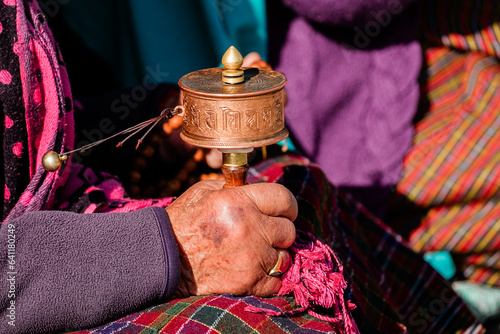 close-up hand of old bhutanese woman praying in Bhutan. Hand holding tibetan prayer wheel
