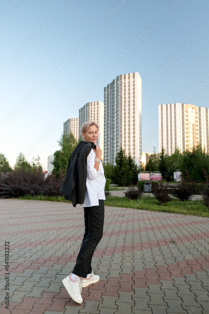Portrait of an attractive middle age older woman walking forward in city. Happy confident 50s person Portrait of an attractive middle age older woman walking forward in city. Happy confident 50s person