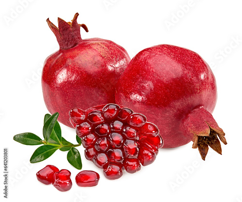 piece of pomegranate with seeds and green leaves isolated on a white background. clipping path