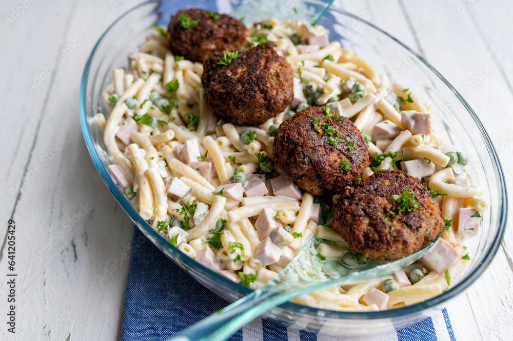 Traditional german dish with fried pork meatballs and homemade pasta salad in a bowl Traditional german dish with fried pork meatballs and homemade pasta salad in a bowl