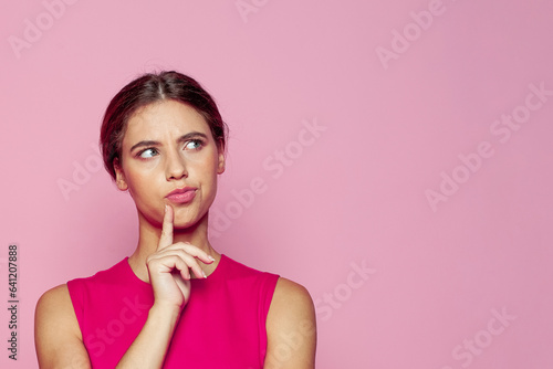 Attractive young woman thinking on pink background. Idea and brainstorming concept photo