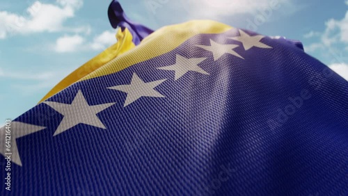 Wavy flag of Bosnia and Herzegovina blowing in the wind in slow motion. Waving colorful Bosnia and Herzegovina flag symbol abstract vertical background. Sun and blue sky with clouds on a background
