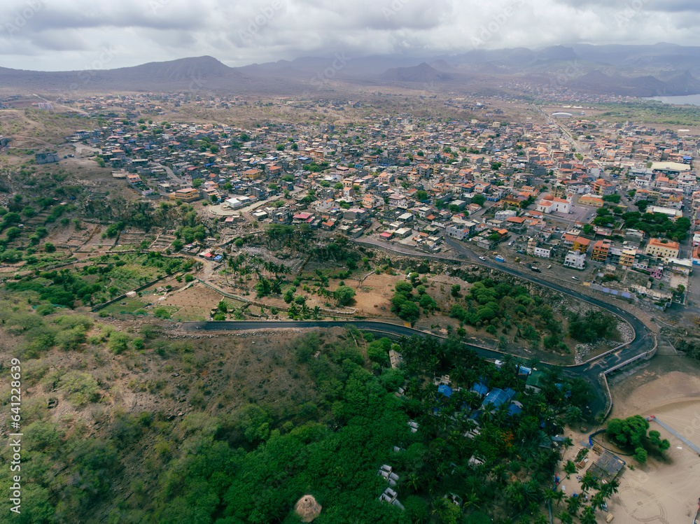 Fototapeta premium Aerial drone Tarrafal in Santiago Island, Cabo Verde showcase golden beaches, azure waters, and rugged mountains, it's a paradise for nature lovers. The charming town, historic sites