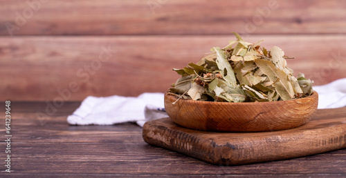 Dried linden flowers. Fresh flowers and leaves of linden in wood bowl. Herbal medicine. Copy space. Empty space for text