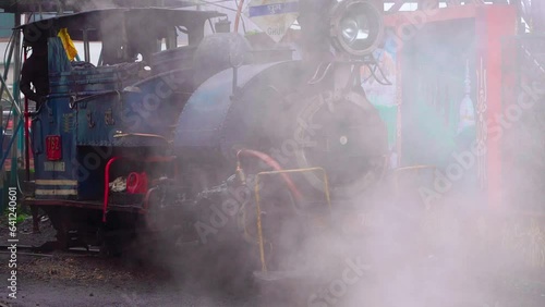 slow motion shot with steam blowing away revealing the world famous tourist attraction toy train on a foggy rainy day in shimla darjeeling