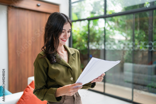 Smiling young business woman holding document. Smiling young business man corporate team leader standing in office. Confident businessman manager.